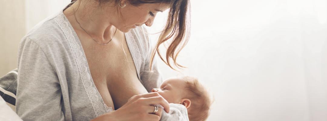 Mutter stillt ihr Baby, Stillen schützt vor Asthma