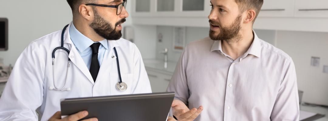 Hispanischer männlicher Arzt, der dem Patienten nach der Untersuchung Beratung gibt, die Ergebnisse der Untersuchung erklärt, Diagnose, auf der medizinischen Couch sitzend, mit dem Mann spricht, medizinische Unterlagen verwendet, Kissen mit Akte hält