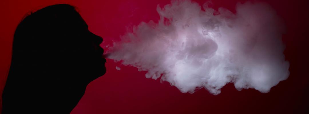 frau bläst Rauch aus