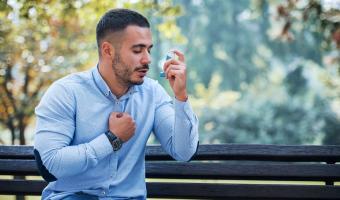 Mann, der Asthma-Inhalator verwendet. Gesundheitswesen
