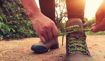 Frau bindet Wanderschuhe