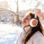 Eine Frau, die im Schneepark frische Winterluft schnuppert